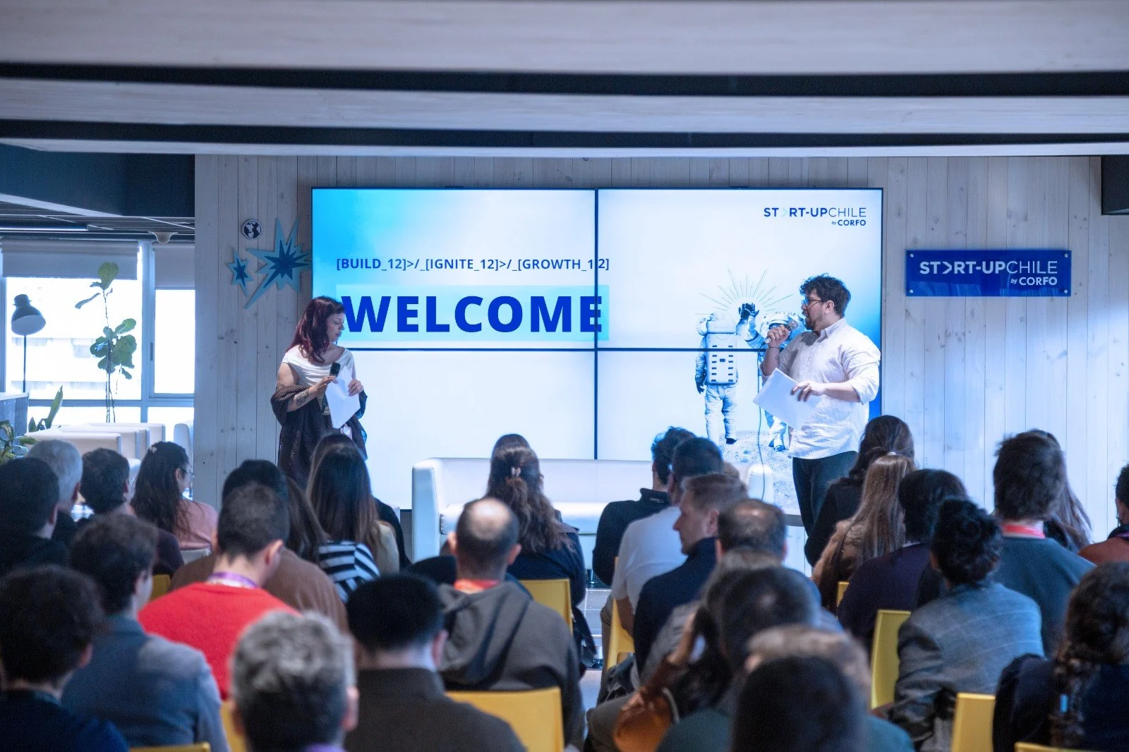 Presentación de bienvenida de BIG 12 en NIDO Lucía, con dos expositores frente a los emprendedores asistentes.